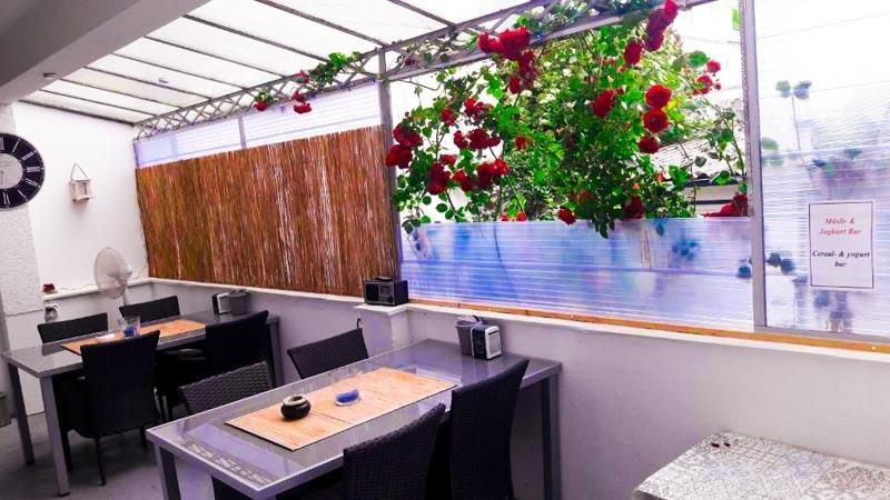 Ein Esszimmer mit Tischen und Stühlen und Blumen, die von der Decke hängen.