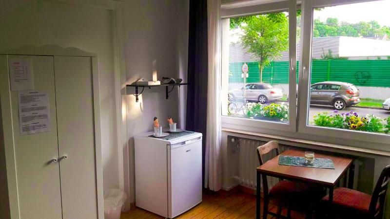 In dem Zimmer mit Fenster stehen ein Tisch und Stühle.