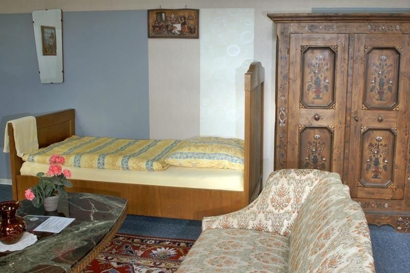 Ein Wohnzimmer mit einer Couch, einem Bett und einem Kleiderschrank