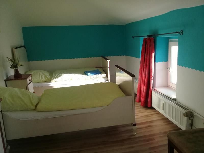 Ein Schlafzimmer mit zwei Betten und blau-weißen Wänden