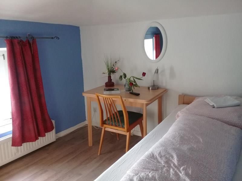 Ein Schlafzimmer mit einem Bett, einem Schreibtisch und einem Spiegel