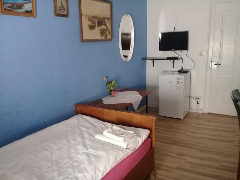 Ein Schlafzimmer mit einem Einzelbett und einem kleinen Kühlschrank