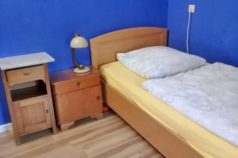Ein Schlafzimmer mit einem Bett, einem Nachttisch und einer Lampe