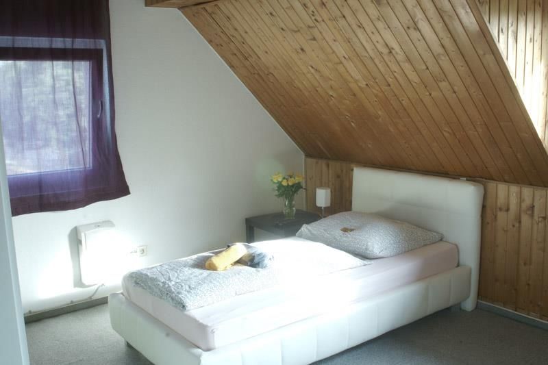 Ein Schlafzimmer mit einem Einzelbett und einem Fenster