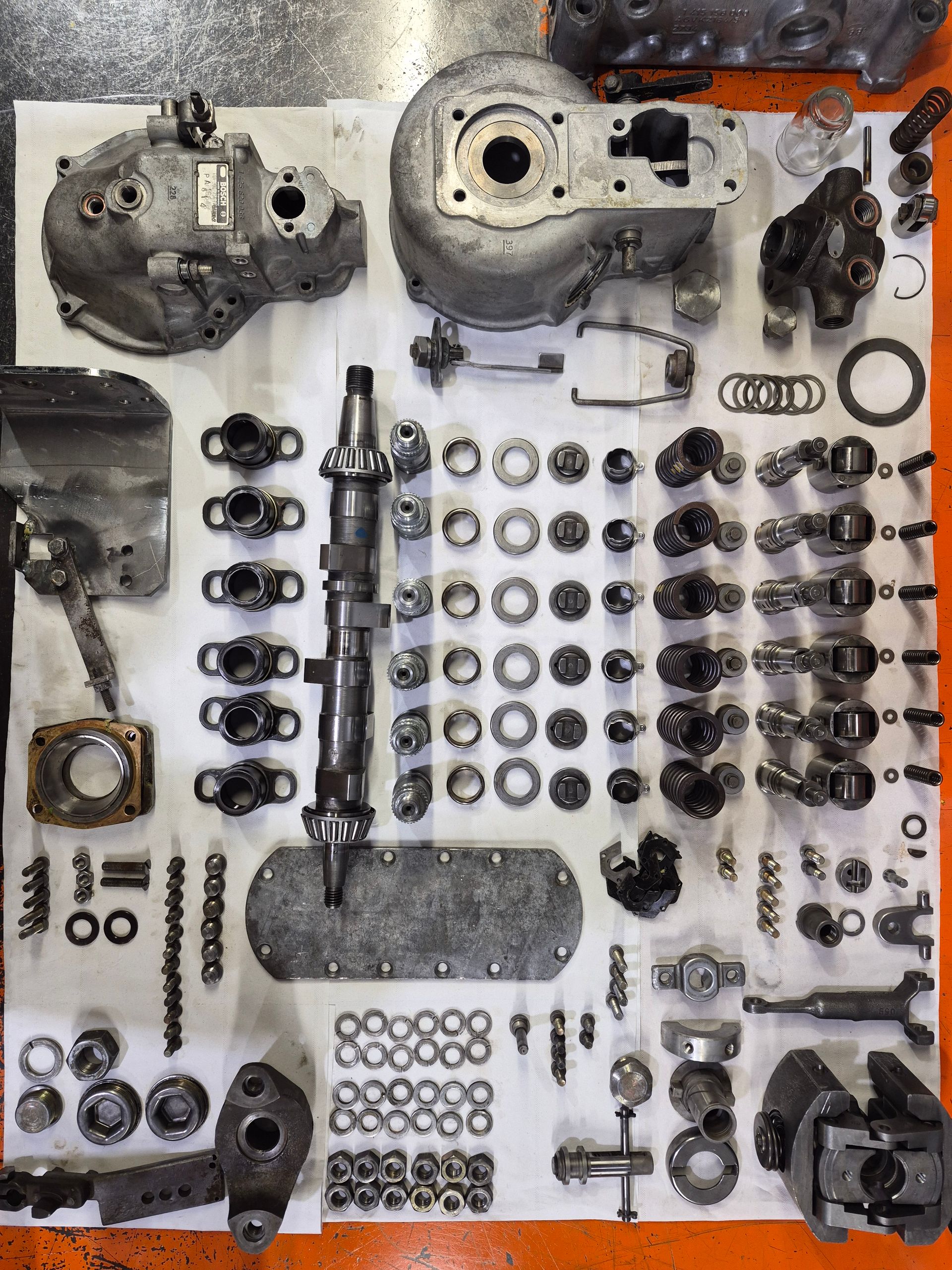 Pièces de transmission de véhicule démontées, disposées sur une surface blanche, prêtes à être inspectées ou réparées.