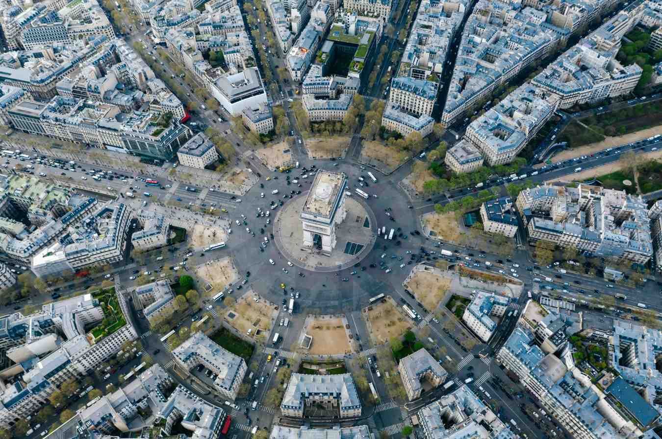 Vista aérea del Arco del Triunfo en París, Francia, rodeado de avenidas radiales y edificios de la ciudad.