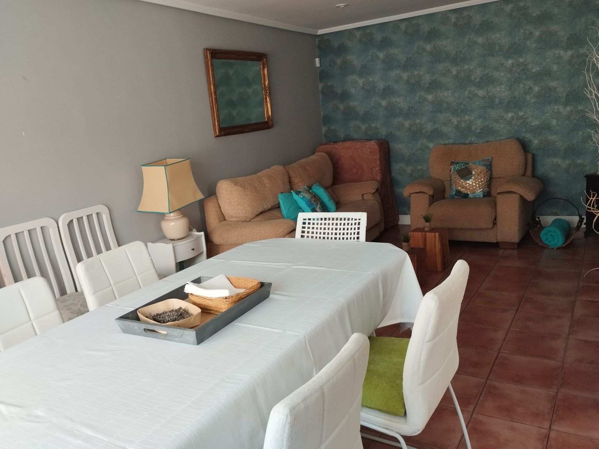 Comedor con mesa y sillas, sofá, sillón y adornos.