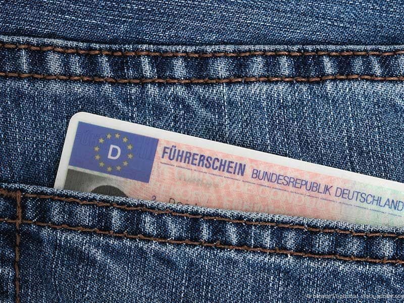 Ein deutscher Führerschein ist teilweise in der Tasche einer blauen Jeans zu sehen, darauf sind die Buchstaben „D“ und „Führerschein“ erkennbar.