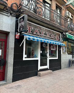 Local comercial a pie de calle con toldo azul y blanco y un letrero negro que dice 