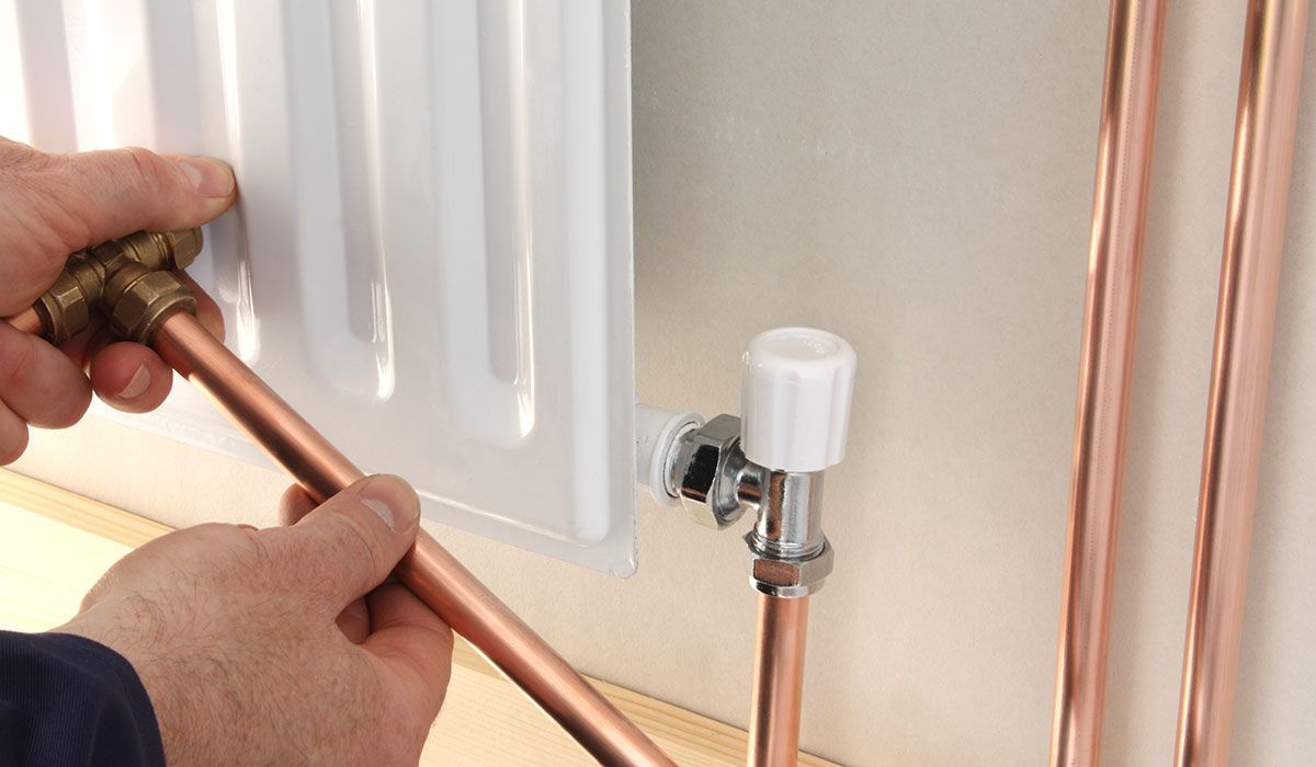 vue de près d'un technicien installant un radiateur