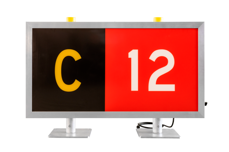 Panneau rouge et noir affichant un « C » jaune et un « 12 » blanc sur un support d'écran