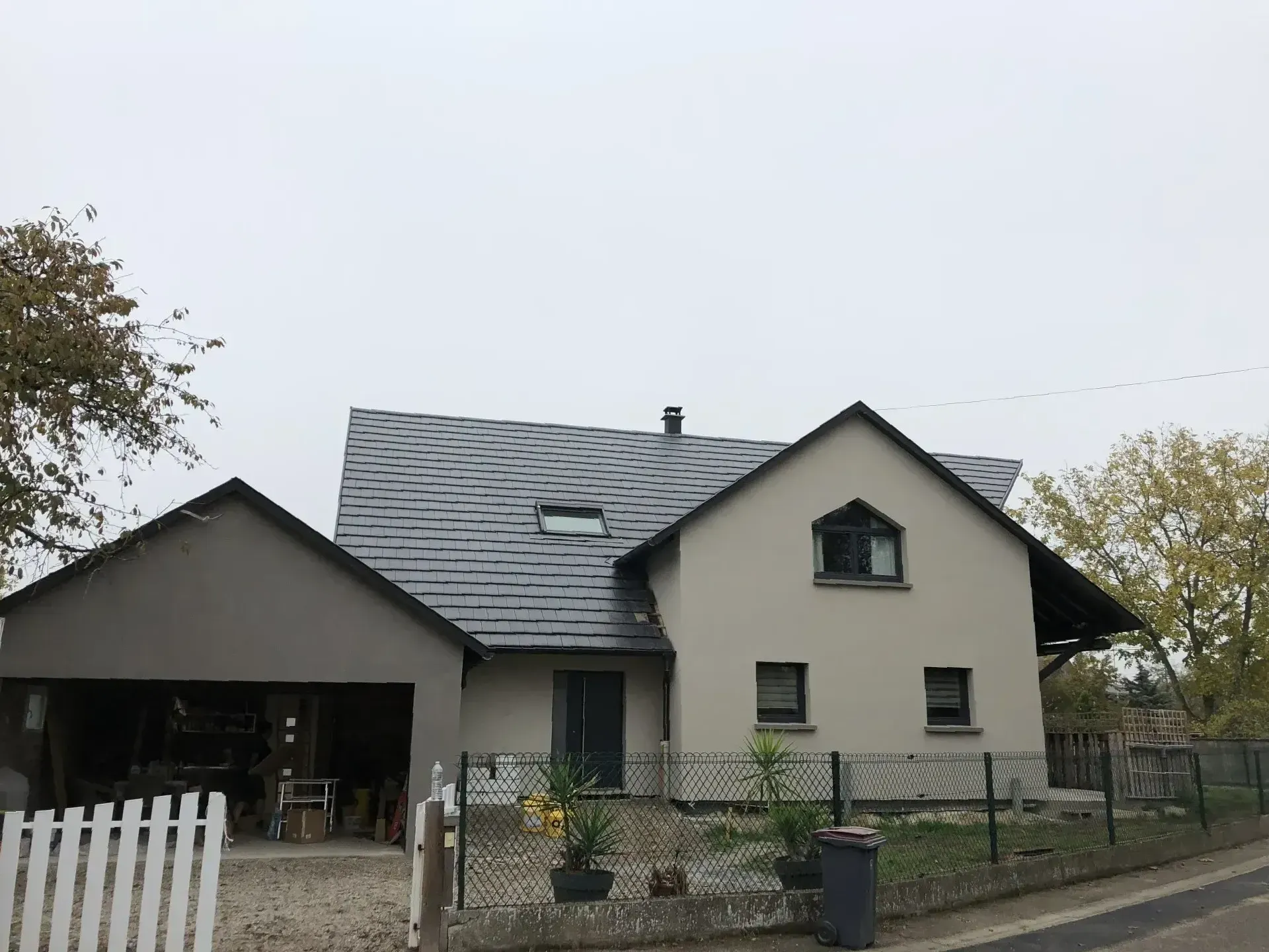 Une maison avec un portail blanc.