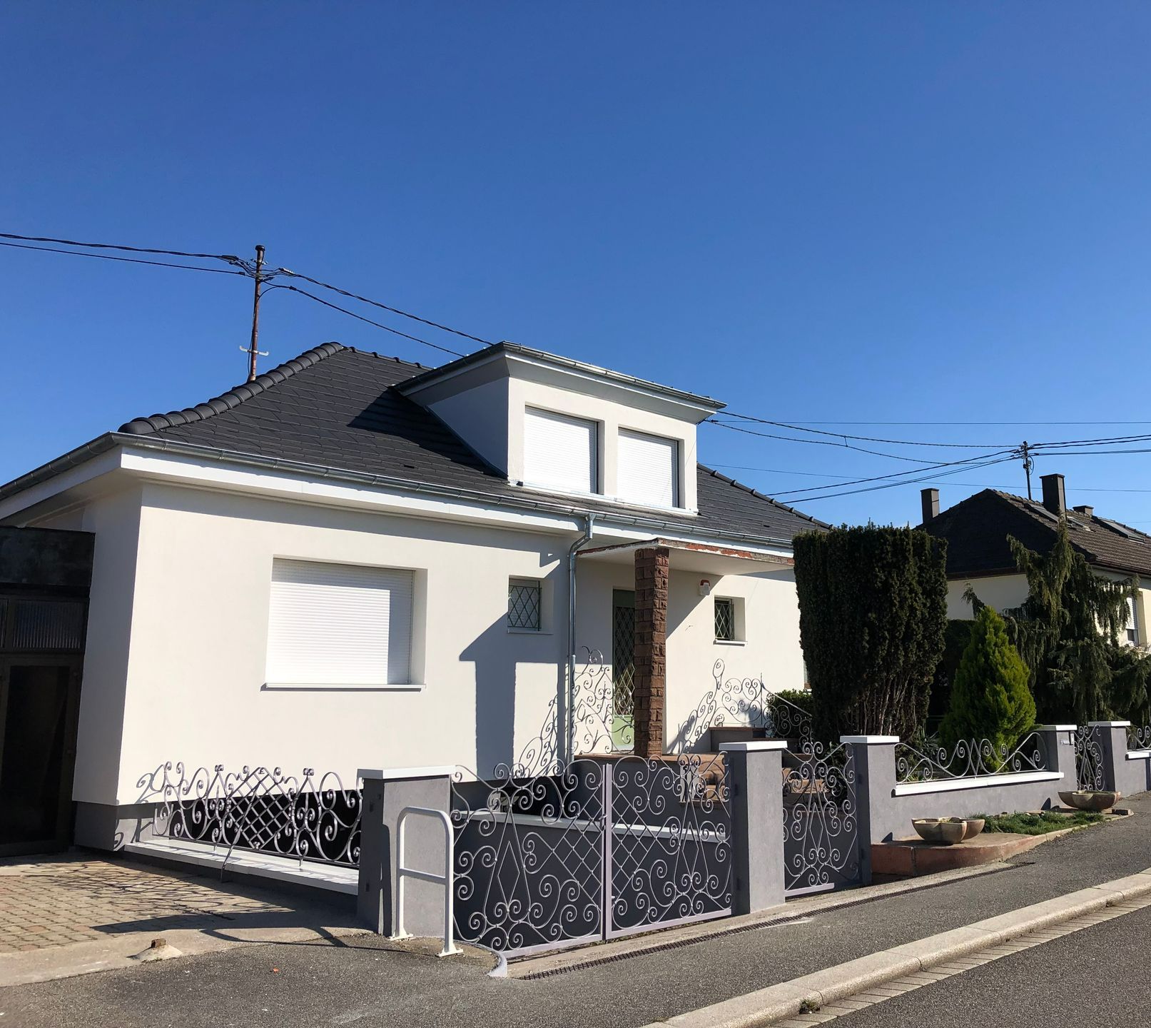 Une maison avec un portail gris