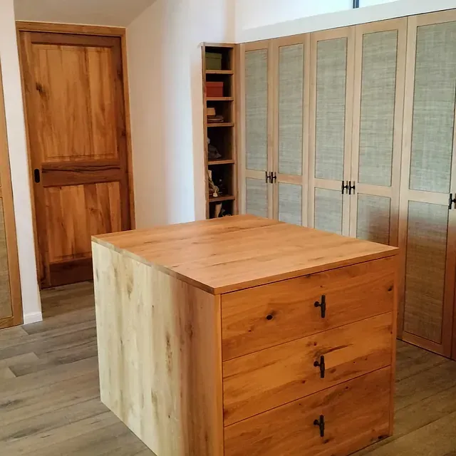 Hay una cómoda de madera en una habitación al lado de una puerta de madera.