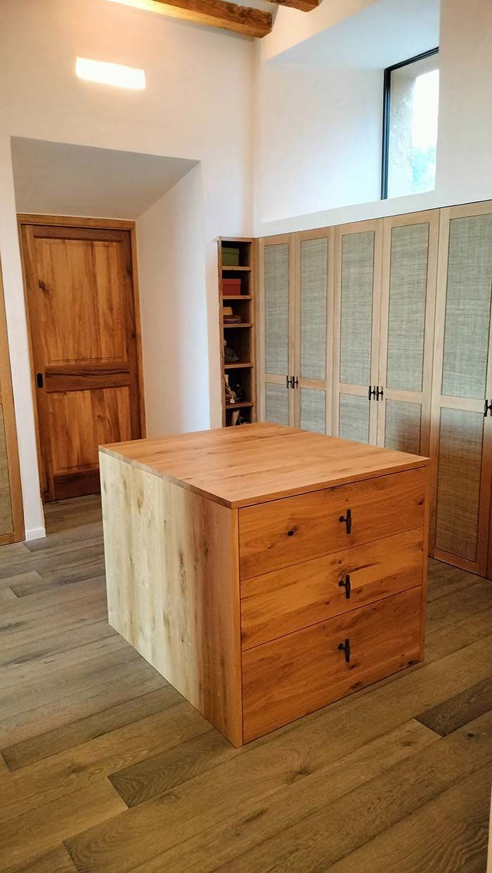 Isla de cocina de madera con cajones, pisos de madera y gabinetes de madera.