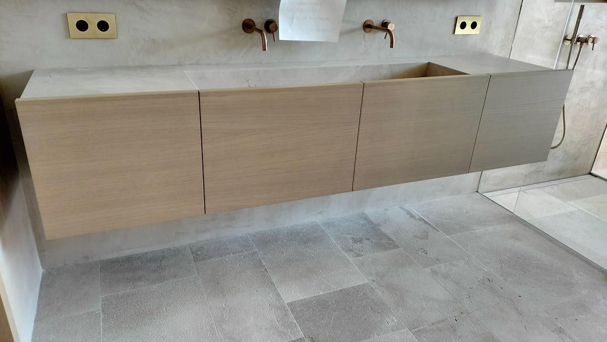 Mueble de baño flotante de madera con tres puertas y grifería de latón.