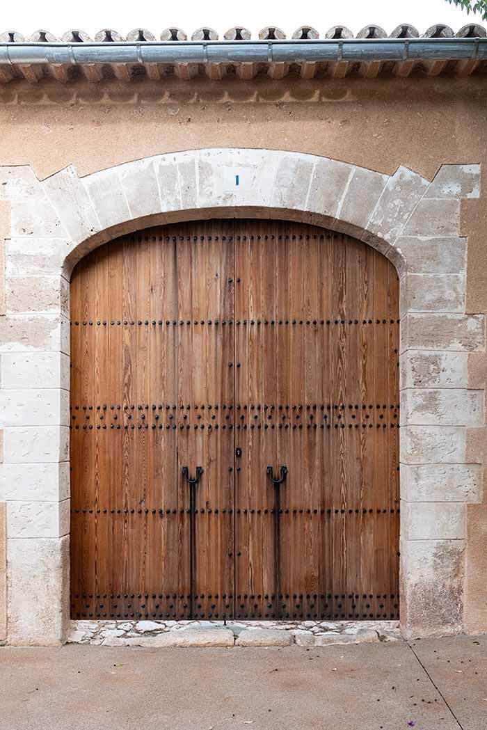 Puerta arqueada de madera con marco de piedra.