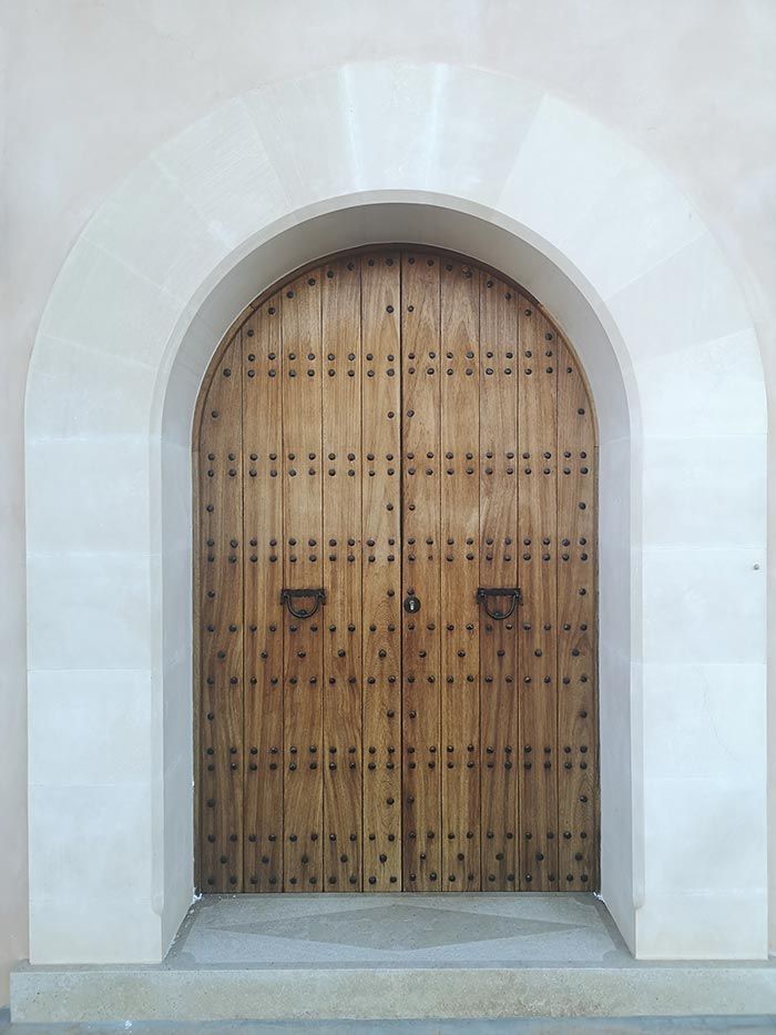 Una puerta de madera con un arco de piedra en un edificio.