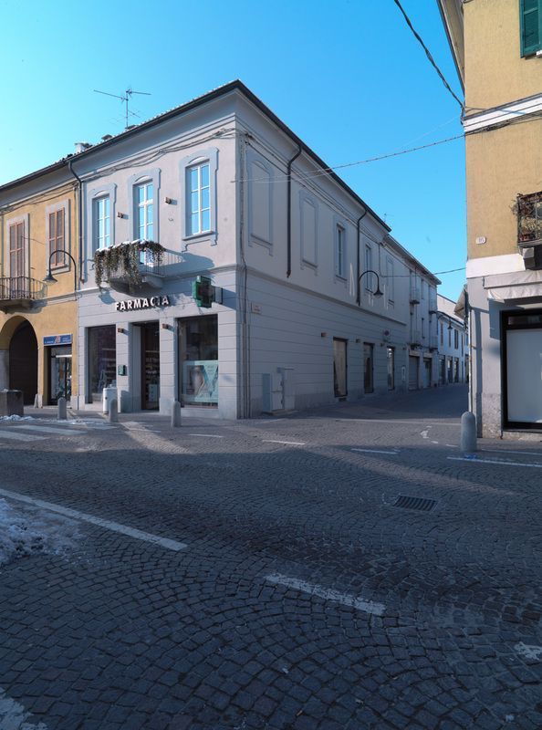 Un farmacista con la barba aiuta una donna in farmacia: entrambi guardano il flacone del medicinale.