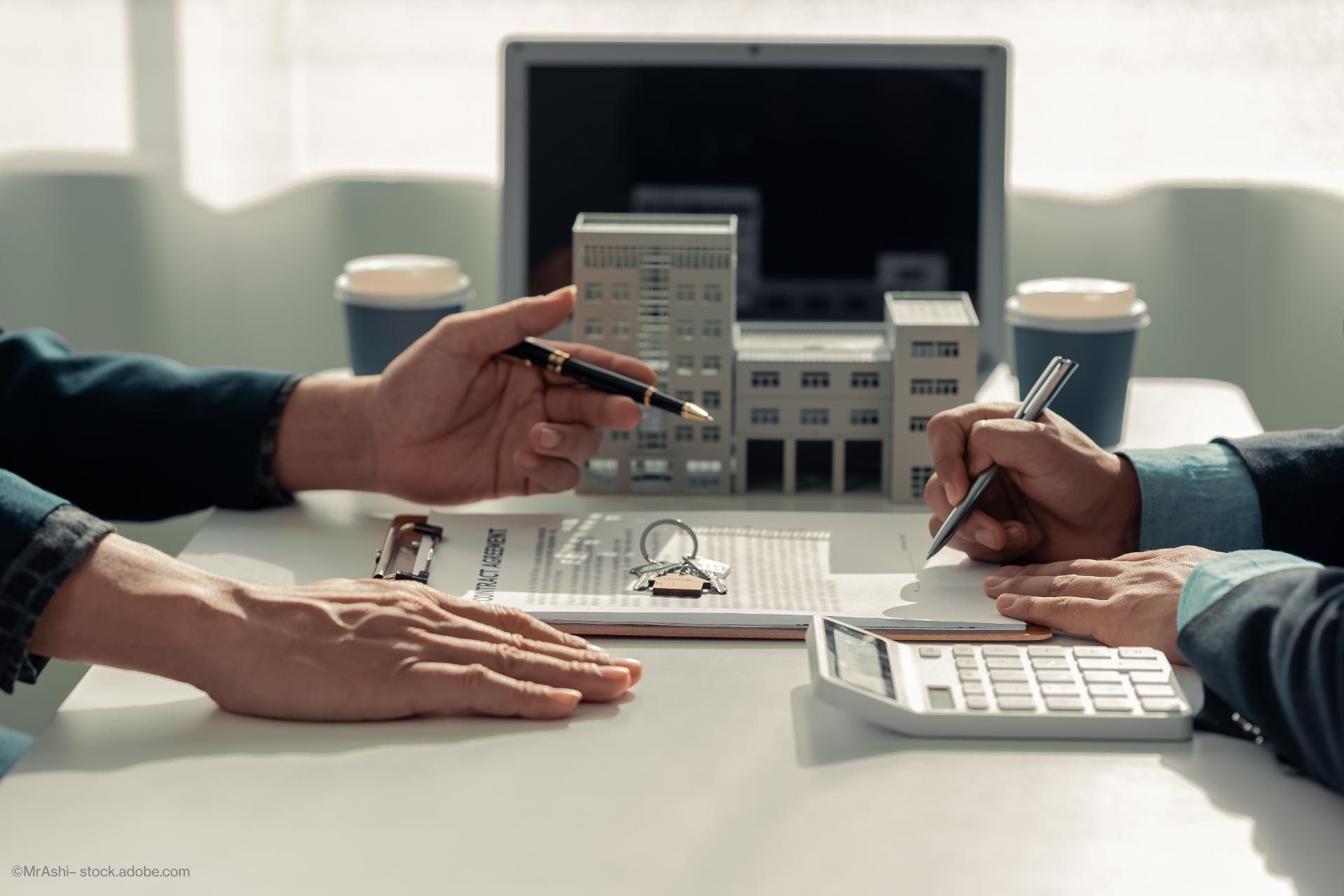 Zwei Personen sitzen sich gegenüber und besprechen einen Vertrag