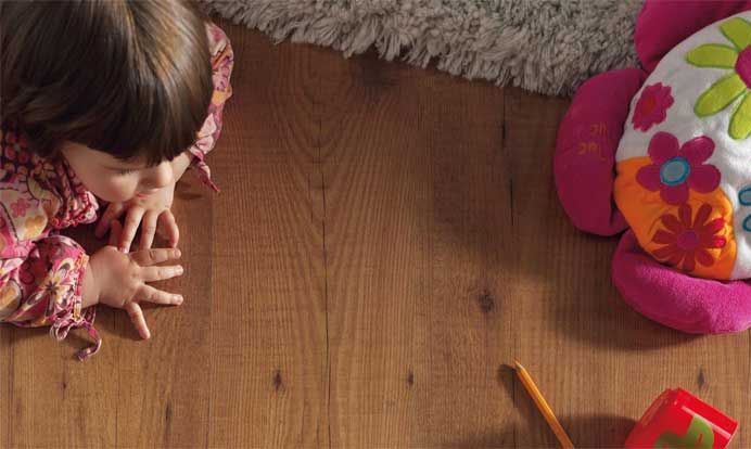 Una niña está sentada en el suelo jugando con juguetes.