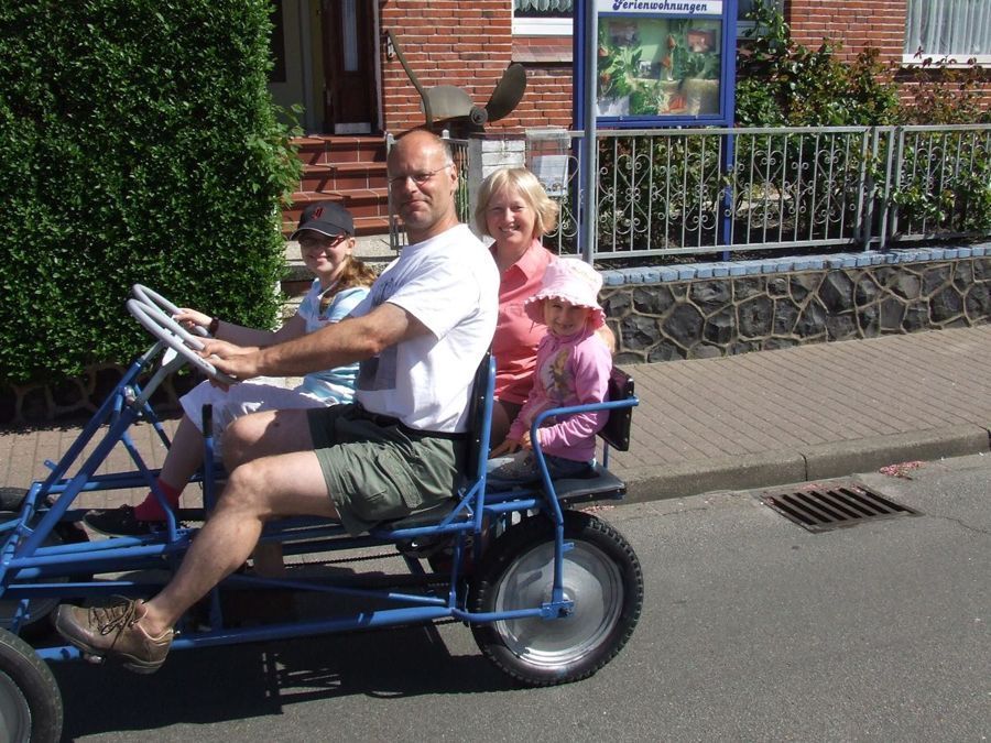 Eine Gruppe von Menschen fährt mit einem Go-Kart eine Straße entlang