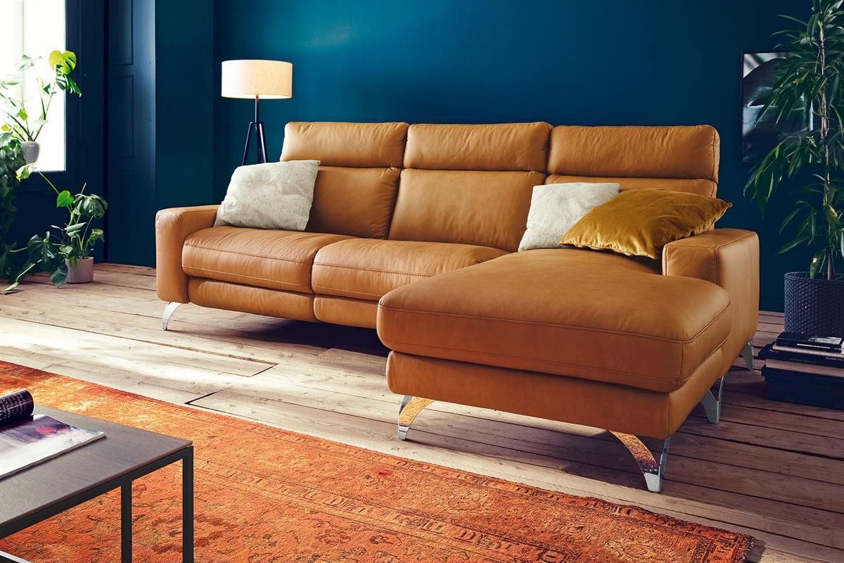 Ein Wohnzimmer mit einer braunen Ledercouch und einer blauen Wand.