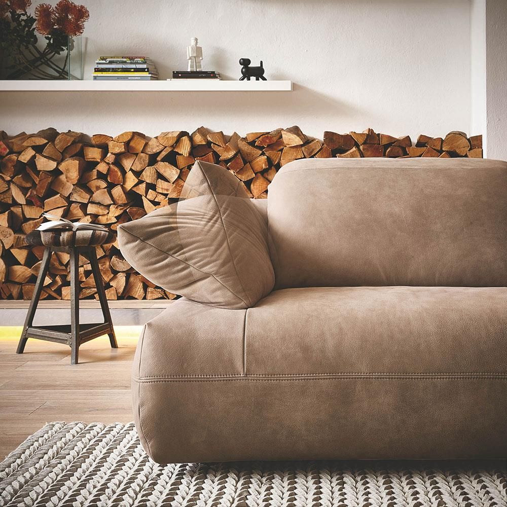 Eine Couch vor einem Stapel Holzscheite