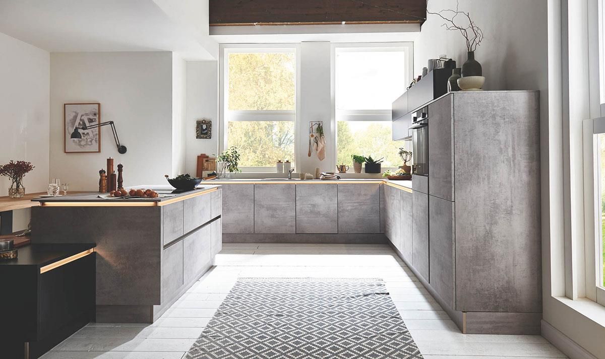 Eine Küche mit vielen Schränken und einem Teppich auf dem Boden.