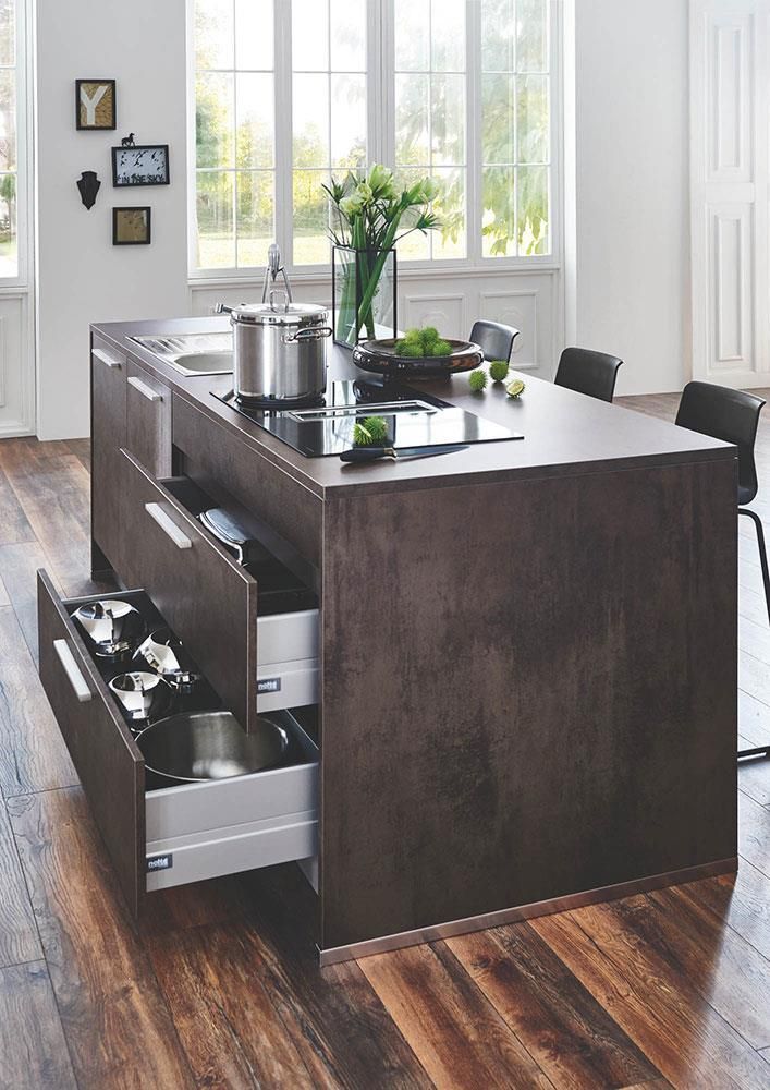 Eine Küche mit einer großen Kochinsel mit offenen Schubladen und einer Spüle.