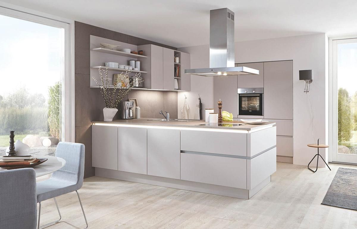 Eine Küche mit weißen Schränken und einer Dunstabzugshaube aus Edelstahl.