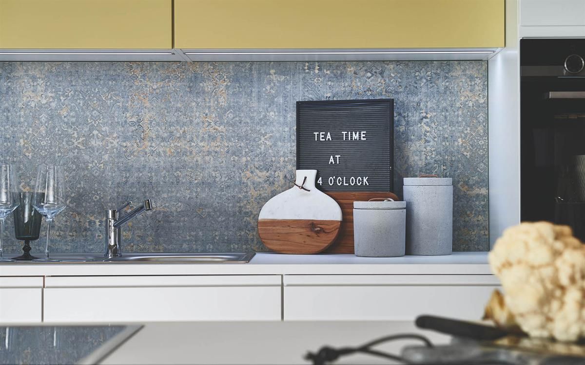 Eine Küche mit weißen Schränken, einem Herd, einer Spüle und einem Schild an der Wand.