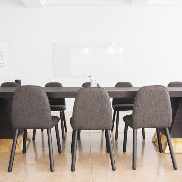 Ein Konferenzraum mit einem langen Tisch und Stühlen.