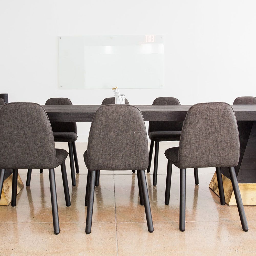 Ein Konferenzraum mit Tisch und Stühlen und einem Whiteboard.