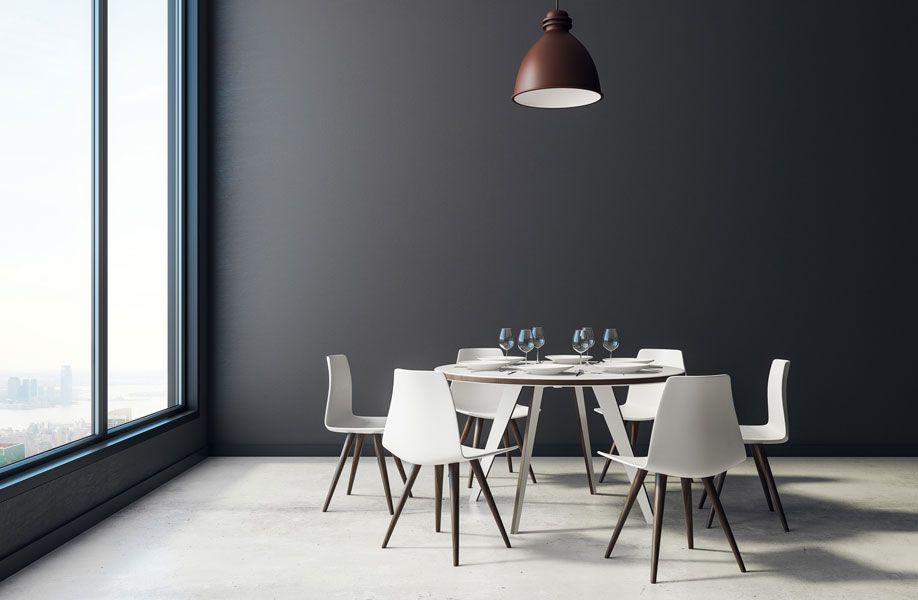 Ein Esszimmer mit einem Tisch und Stühlen vor einem Fenster.