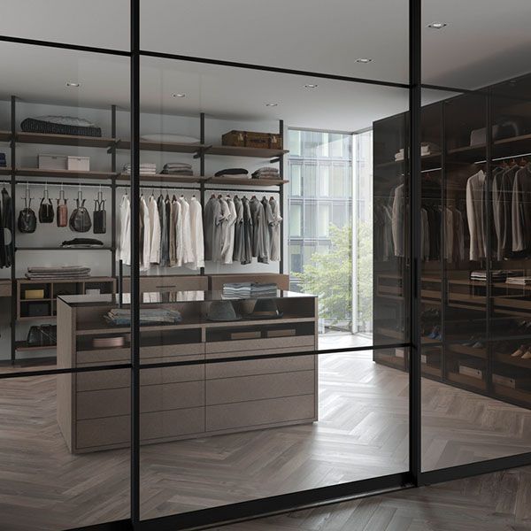 Ein begehbarer Kleiderschrank mit Glasschiebetüren