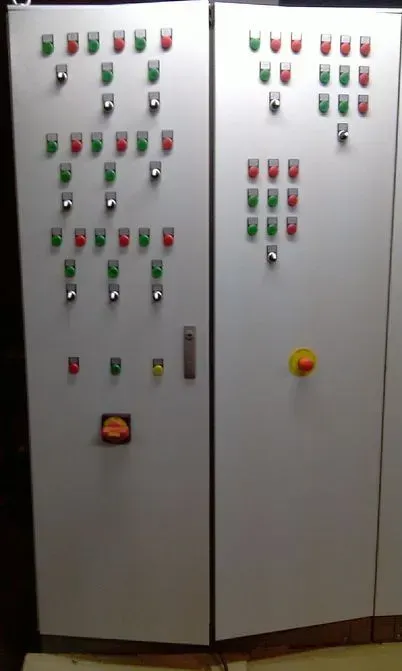 Painel de controle com muitas luzes vermelhas e verdes e interruptores em portas brancas.