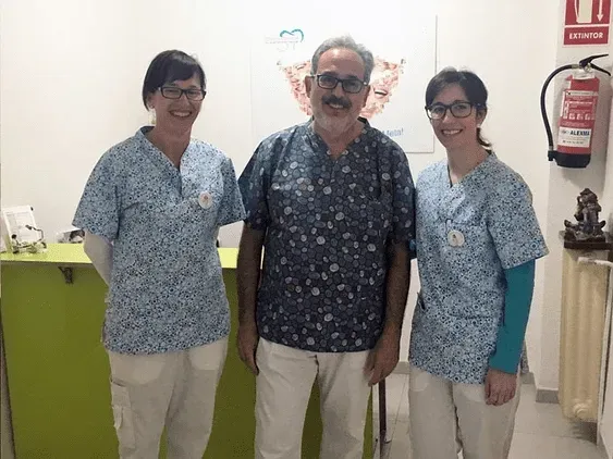 Un hombre y dos mujeres están parados uno al lado del otro en una habitación.