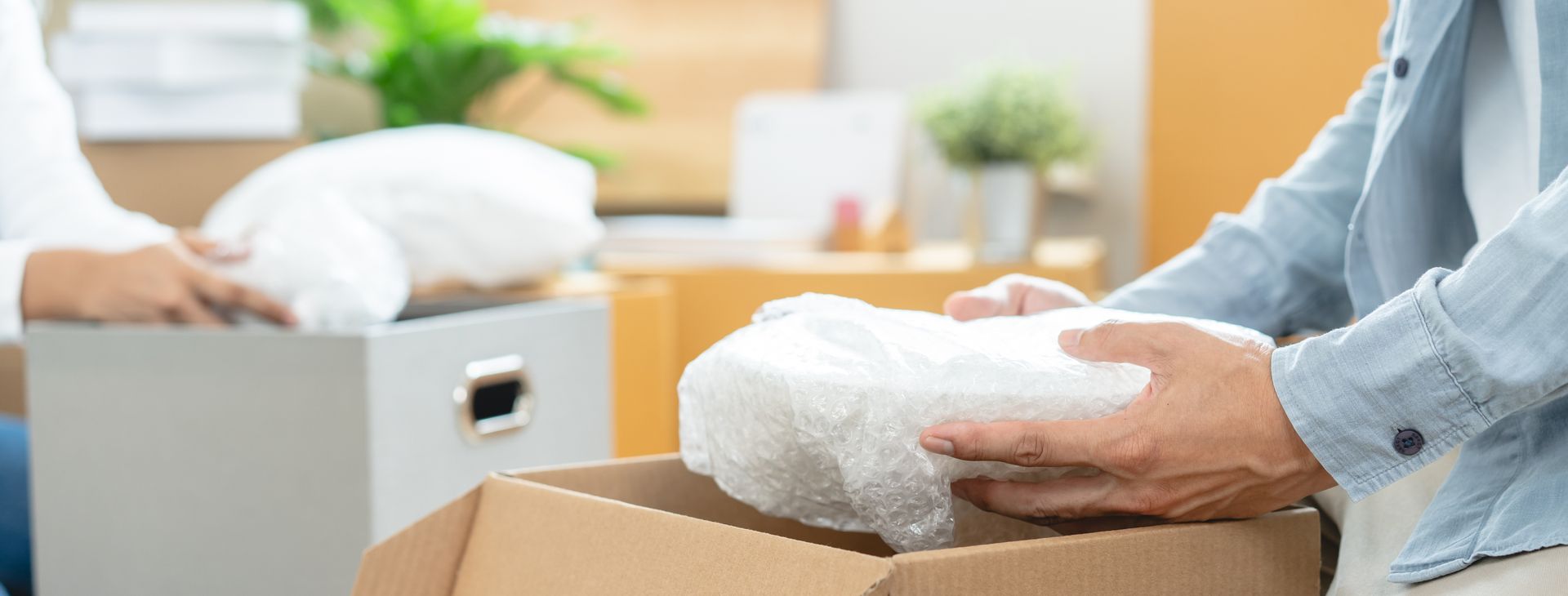 Une personne qui range de la vaisselle dans un carton