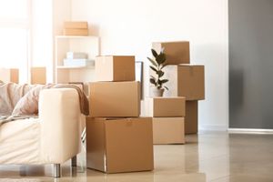 Des boîtes en cartons empilées à côté d'un canapé