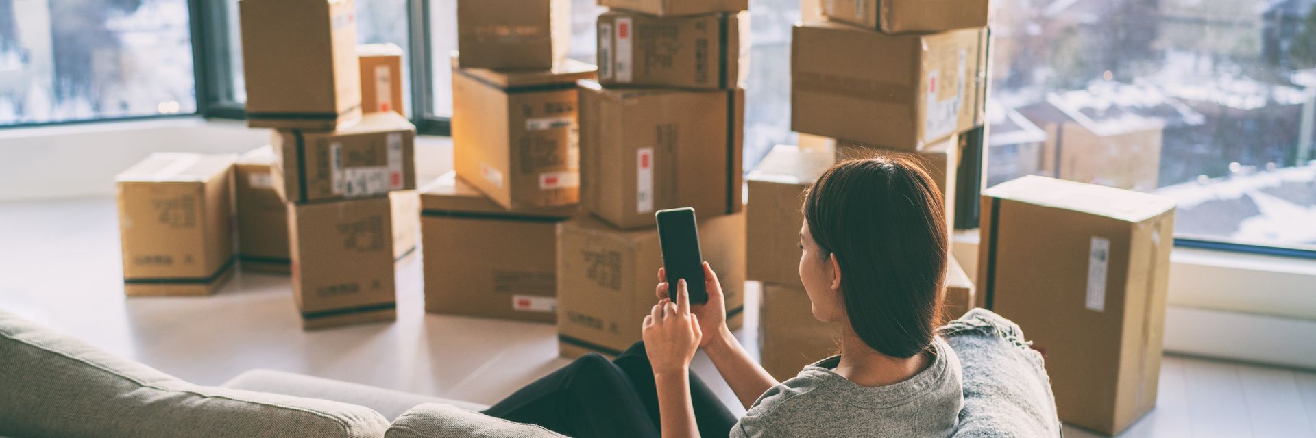Une femme sur son téléphone avec des cartons