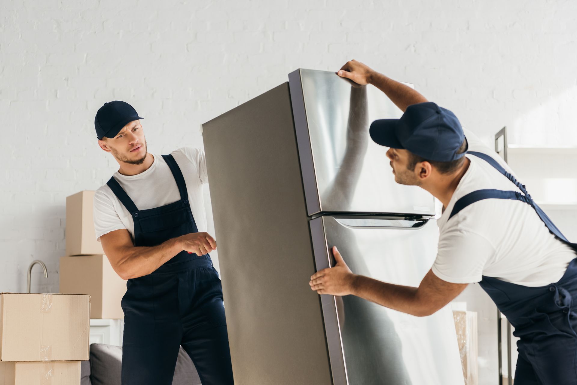 2 hommes qui déménagent un réfrigérateur