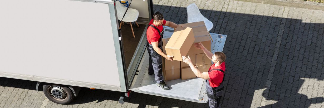 Deux déménageurs qui déchargent un camion
