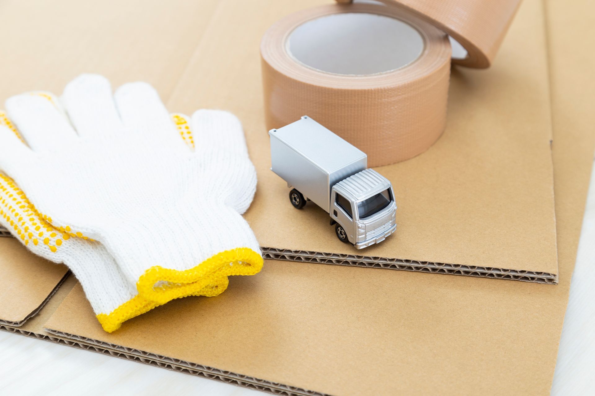 Une paire de gants, un carton, du scotch et un petit camion