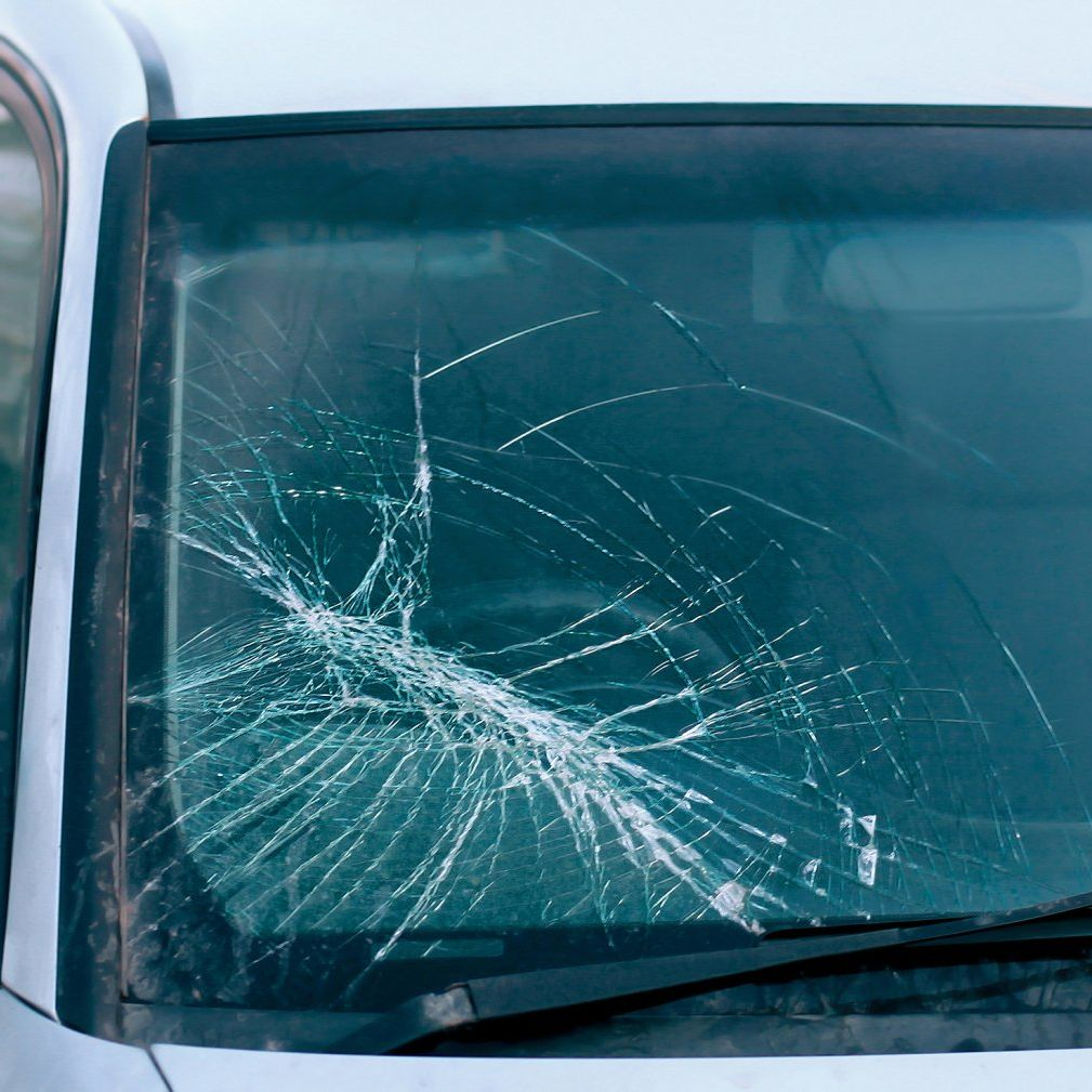 Le pare-brise d'une voiture est cassé sur le côté gauche.