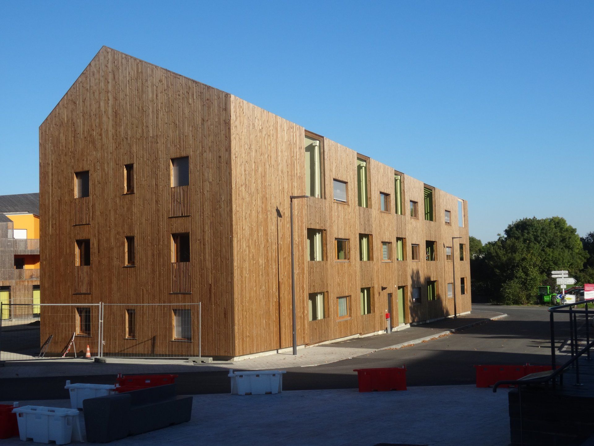Bâtiment en bois avec de nombreuses fenêtres ; ciel bleu en arrière-plan.