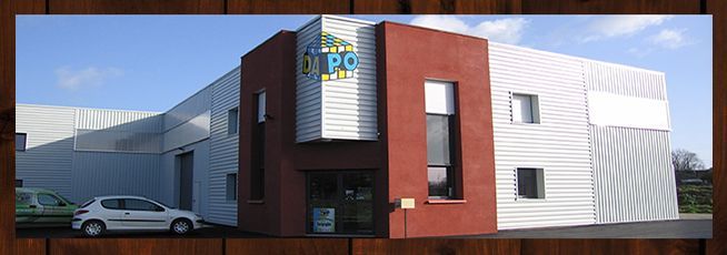 Extérieur du bâtiment avec façade rouge et blanche, ciel bleu, voitures garées.