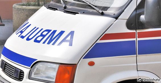 L'avant d'une ambulance blanche avec des rayures bleues et rouges et l'inscription AMBULANCE en miroir sur le capot