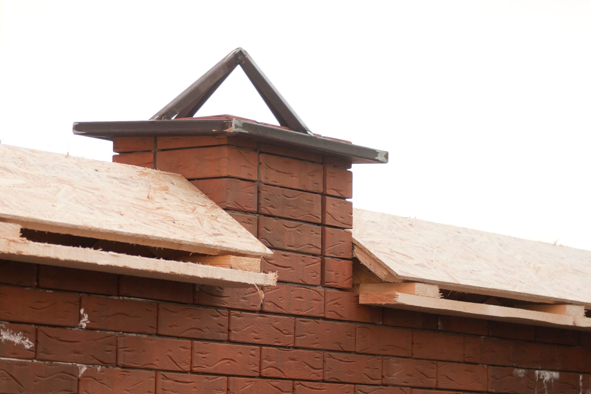 Un camino in mattoni viene costruito sopra un tetto in legno.
