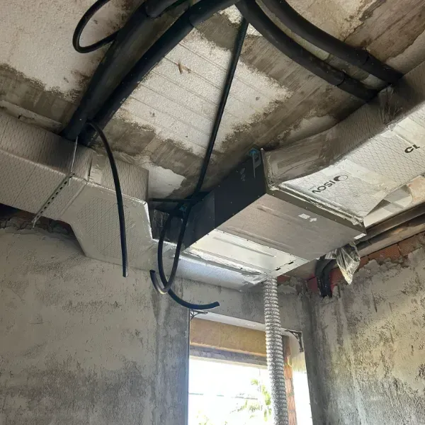 Instalación de conductos de climatización en un edificio en construcción. Se ven conductos metálicos aislados.